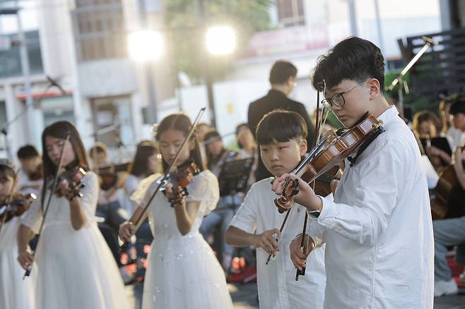 지난 14일 포항 철길 숲에서 진행된 ‘찾아가는 클래식 연주회 철길 숲 하모니’에서 스즈키바이올린 원생 40여 명이 바이올린 연주를 진행하고 있다. /포스코 제공
