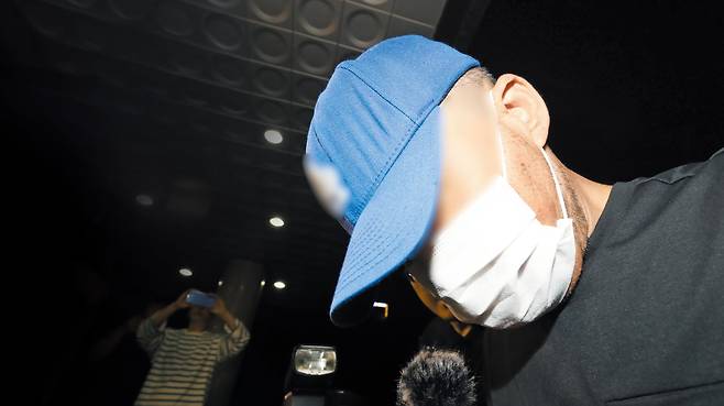 대구에서 스토킹하던 여성을 살해한 40대 용의자 A씨가 15일 오전 2시 15분쯤 대구 성서경찰서로 압송되고 있다. 고개를 푹 숙인 채 모자와 마스크로 얼굴을 가렸다. 그는 취재진의 질문에 아무런 대답도 하지 않고 경찰서로 들어갔다. /뉴스1