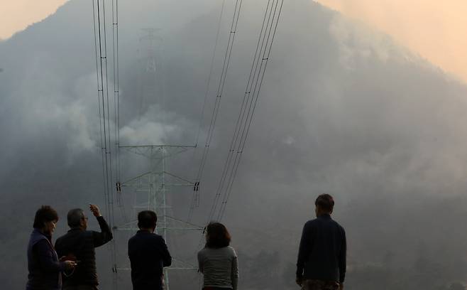 지난 3월 발생한 경남 산청 산불 당시 주민들이 산불 연기가 치솟아오르는 모습을 지켜보고 있다. /뉴스1