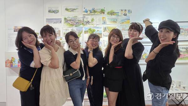 2025 수원시미술단체 아카이브전에 참여한 ‘모닝어스’ 회원들이 작품 앞에서 환하게 웃고 있다. 이나경기자