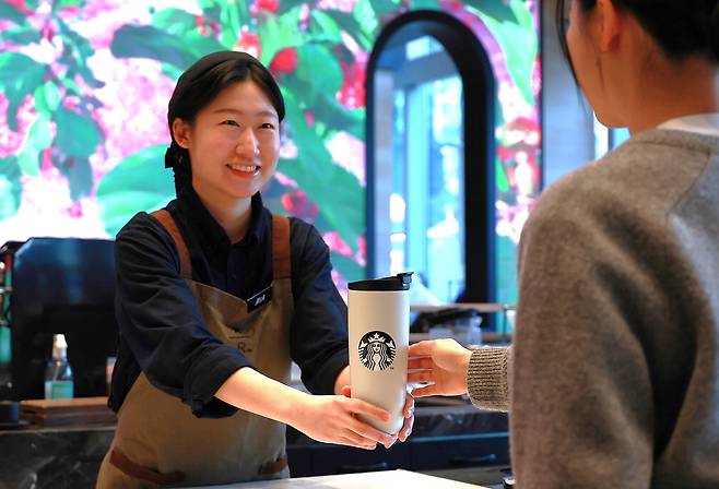 스타벅스 직원이 개인 컵 이용고객에 음료를 전달하는 모습.