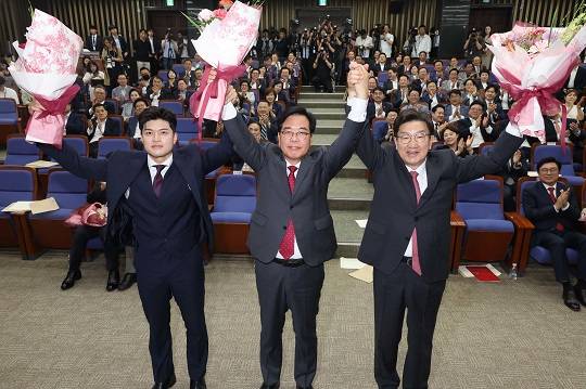 사진 = 어제(16일) 국회에서 열린 국민의힘 원내대표 선출 의원총회에서 새 원내대표로 당선된 송언석 의원(가운데)이 두 팔 들어 인사하고 있다. 왼쪽부터 김용태 비상대책위원장, 송 신임 원내대표, 권성동 전 원내대표. (뉴스1)