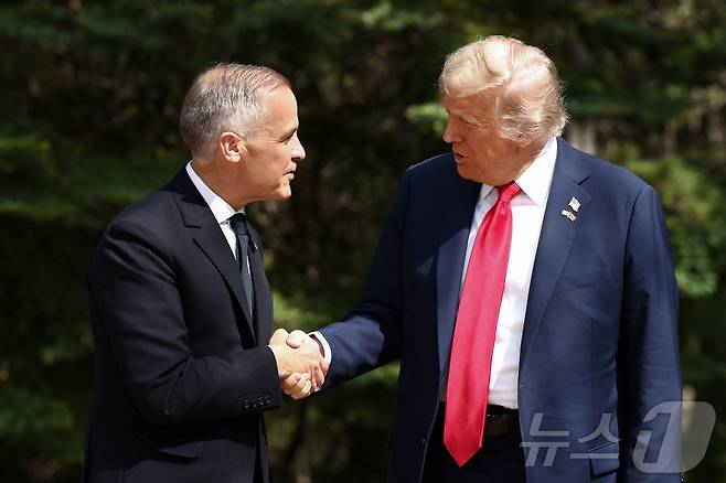 도널드 트럼프 미국 대통령과 마크 카니 캐나다 총리가 16일(현지시간) 캐나다 앨버타주 캐내내스키스에서 열린 주요 7개국(G7) 정상회의 공식 환영 행사에서 악수하고 있다. 2025.06.16 ⓒ 로이터=뉴스1 ⓒ News1 류정민 특파원
