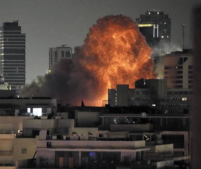 15일 이스라엘 수도 텔아비브에 떨어진 이란의 미사일로 인해 건물에서 화염과 연기가 피어오르고 있다. /AP 연합뉴스