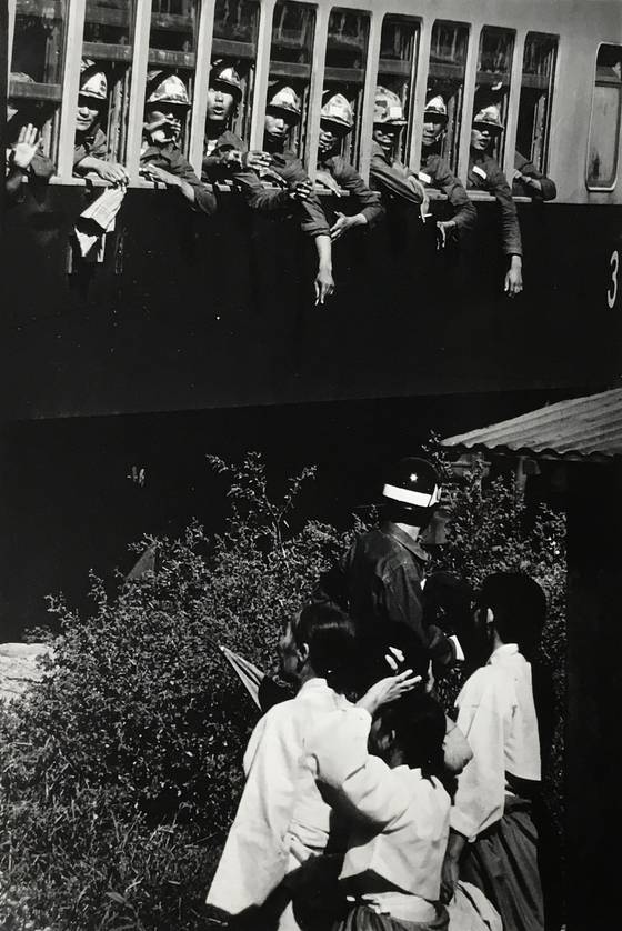 1965년 베트남전 참전을 위해 열차를 타고 떠나는 맹호부대. 치마 저고리를 입은 아내들이 언제 돌아올지 알 수 없는 아들과 남편을 보기 위해 떠나가는 기차를 애타게 바라보고 있다. 사진 구와바라 시세이