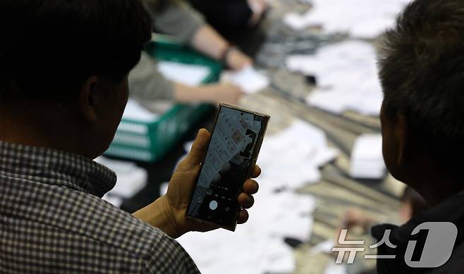 제21대 대통령 선거 투표가 실시된 3일 대전 서구 KT인재개발원에 마련된 개표소에서 개표 관람인들이 투표용지 분류 상황을 촬영하고 있다. 2025.6.3/뉴스1 ⓒ News1 김기태 기자