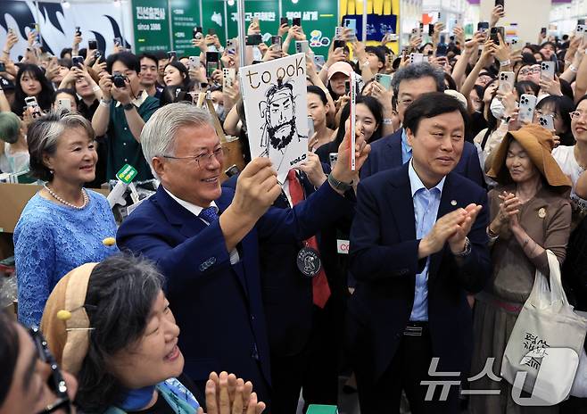 문재인 전 대통령과 김정숙 여사가 18일 오후 서울 강남구 삼성동 코엑스에서 열린 2025 서울국제도서전 평산책방 부스를 찾아 괴산로컬잡지 툭의 임꺽정 특집호를 들어 보이고 있다. 2025.6.18/뉴스1 ⓒ News1 박정호 기자