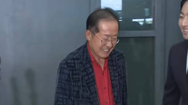 홍준표 전 시장이 17일 귀국 직후, 인천국제공항에서 정치 현안에 대해 기자들에게 입장을 밝힌 후 자리를 떠나고 있다. (SBS 캡처)