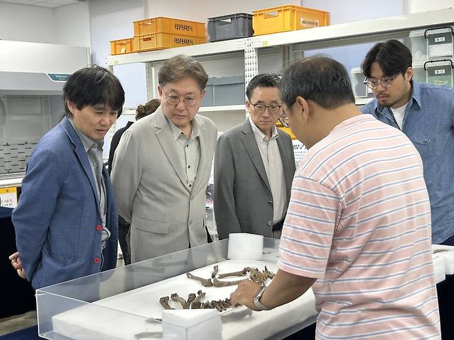 월성 출토 개, 유전자 분석·연구 어떻게? (경주=연합뉴스) 김예나 기자 = 임종덕 국립문화유산연구원장(왼쪽에서 두 번째)이 지난 11일 경북 경주시 신라월성연구센터 숭문대를 찾아 월성 남성벽에서 출토된 개 뼈를 살펴보고 있다. 임 원장 왼쪽은 박종화 울산과학기술원(UNIST) 바이오메디컬공학과 교수, 오른쪽은 류덕영 서울대 수의과대학 교수. 2025.6.18
yes@yna.co.kr