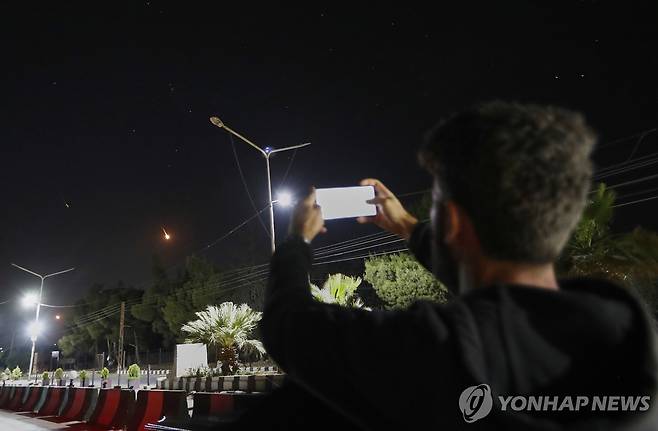 밤하늘의 이란 미사일을 촬영하는 시리아인 (다마스쿠스 AP=연합뉴스) 16일 밤 시리아에서 한 남성이 다마스쿠스 상공을 지나 이란 미사일을 촬영하고 있다.