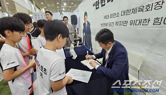 유승민 대한체육회장이 서울국제도서전 현장서 열린 자전에세이 '원모어' 북토크에 참가한 하남G스포츠클럽 배드민턴 꿈나무들에게 사인을 해주고 있다. "재아야, 네 꿈을 응원해!"라는 따뜻한 메시지를 전했다.