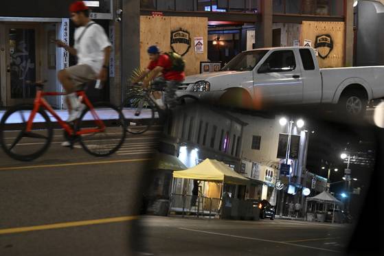 17일(현지시간) 로스앤젤레스 리틀 도쿄의 1번가를 따라 시민들이 자전거를 타고 이동하고 있다. AP=연합뉴스