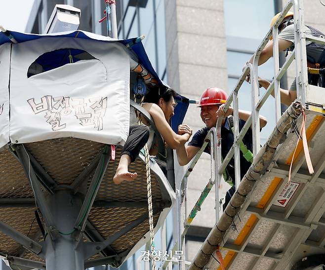 한화오션 거제사업장 하청노사가 2025년 임금단체협약에 잠정합의한 가운데 서울 장교동 한화 본사 앞 철탑에 올라 97일째 고공농성을 벌이던 김형수 전국금속노조 거제통영고성조선하청지회장이 19일 장창열 금속노조 위원장과 손을 맞잡으며 인사하고 있다. 2025.06.19 문재원 기자