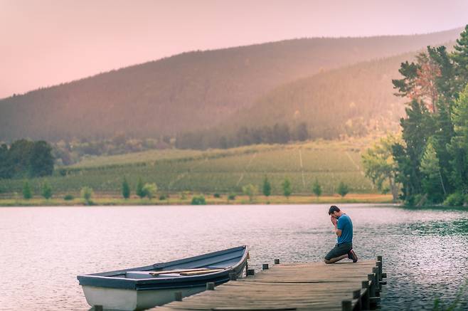 무언갈 위해 간절히 기도할 때 문득 이런 생각이 들 수 있습니다. “하나님이 정말 내 기도를 듣고 있을까. 이 기도는 과연 이뤄질까?” ‘무릎으로 사는 그리스도인’은 이런 질문을 품는 이들을 위해 쓰인 책입니다. 사진은 한 남성이 강변에서 무릎 꿇고 기도하는 모습. 게티이미지뱅크