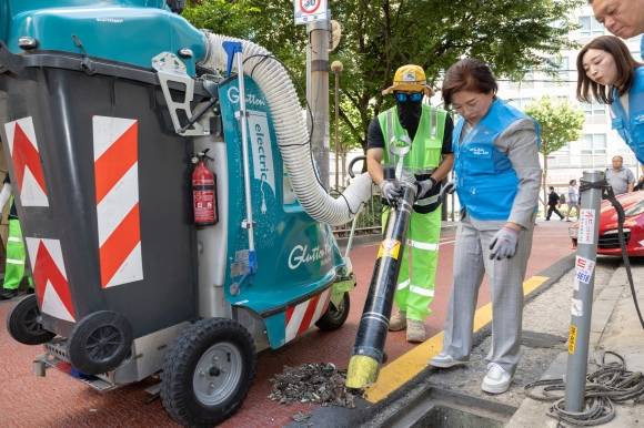 지난 11일 서울 은평구 응암동 골목을 돌며 빗물받이를 점검하고 주변 청소에 나선 김미경(왼쪽 두 번째) 은평구청장이 환경공무관과 함께 ‘친환경 도시 청소기’를 사용하고 있다. 은평구 제공