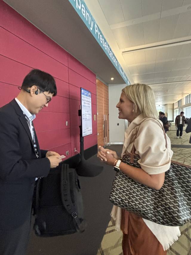 전승호(왼쪽) 코오롱티슈진 대표가 18일(현지시간) 미국 보스턴 바이오USA에서 기업 발표를 바친 후 업계 관계자로부터 명함을 건네받고 있다. 이정민 기자