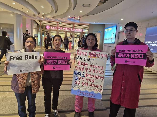 2025년 4월15일 핫핑돌 조약골 대표(왼쪽에서 세 번째)와 시민들이 서울 잠실 롯데월드 아쿠아리움 앞에서 손피켓을 들고 서 있다. 핫핑크돌핀스 누리집 갈무리