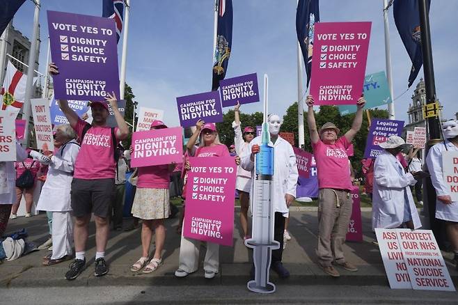 20일(현지시간) 런던 중심부의 국회의사당 광장에서 지지와 반대 운동가들이 뒤섞여 말기 성인(종말) 법안에 대한 토론을 앞두고 시위를 벌이고 있다. AP 연합뉴스