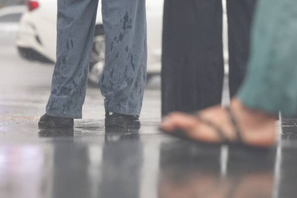 서울 전역에 호우주의보가 내린 20일 서울 종로구 광화문 네거리에서 한 시민의 바지 밑단이 빗물로 젖어있다. 연합뉴스