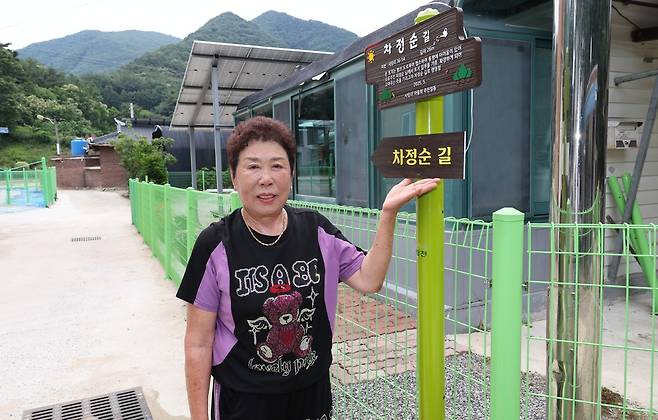 충북 괴산군 청천면 사담1리 마을 길 입구에 놓은 ‘차정순 길’ 푯말 앞에서 차정순씨가 길을 소개하고 있다. 괴산군 제공