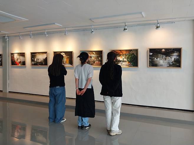 2023년 5월 의성군 청년인큐베이팅 공간 G-town에서 관객들이 성광성냥공업사 흔적을 담은 작품들을 관람하고 있다. /박정일 작가