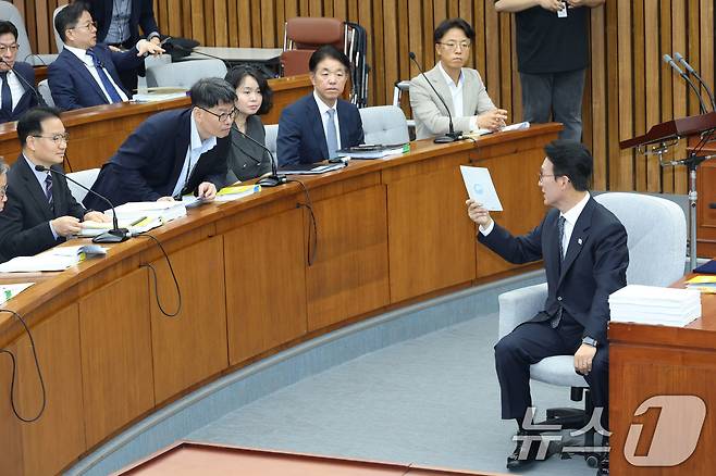 김민석 국무총리 후보자가 24일 오전 서울 여의도 국회에서 열린 인사청문회에 출석해 메모지를 들어보이며 관계자들과 대화하고 있다. 2025.6.24/뉴스1 ⓒ News1 이광호 기자
