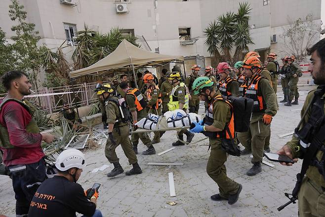 이스라엘 군인과 구조대원들이 24일 이란의 미사일 공격으로 파괴된 이스라엘 남부 베르셰바의 주거용 건물에서 주검을 옮기고 있다. 베르셰바/AP 연합뉴스