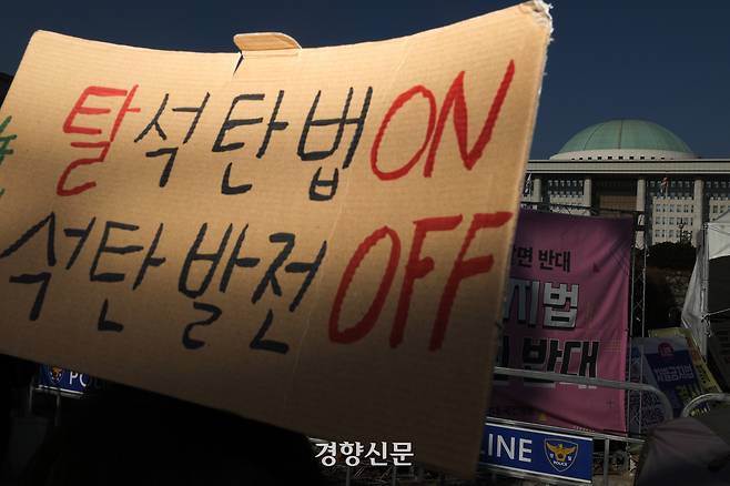 환경운동연합 등 환경단체 회원들이 국회 앞에서 탈석탄법 제정을 촉구하는 손피켓을 들고 있다. 성동훈 기자