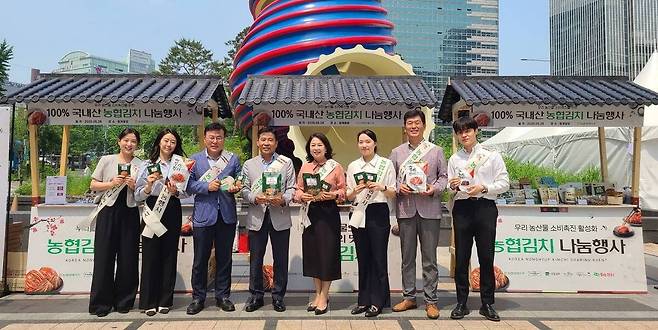 서승일 한국농협김치조공법인 사업전무(왼쪽에서 4번째)와 장지윤 농협경제지주 식품지원부장(왼쪽에서 5번째)이 지난달 28일 서울시 중구 청계광장에서 국산 김치의 우수성을 알리기 위한 농협김치 나눔행사를 개최하고 기념사진을 촬영하고 있다. 농협중앙회 제공