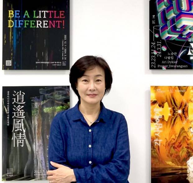 김허경 센터장이 지난 2022년 G.MAP개관 이후 펼쳐졌던 기획전, 특별전 관련 포스터 앞에서 포즈를 취했다.