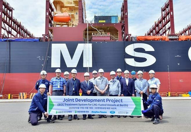 건조 중인 LNG 연료 추진선의 증발가스를 육상 도시가스로 재활용하는 기술에 대한 실증을 진행하는 현장에서 관계자들이 기념사진을 촬영하고 있다. 한국선급 제공