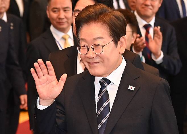 이재명 대통령이 26일 서울 여의도 국회에서 정부의 추가경정예산안 제출과 관련해 첫 시정연설을 마친 뒤 본회의장을 나와 이동 중 국회 직원들에게 손을 흔들고 있다. 국회사진기자단