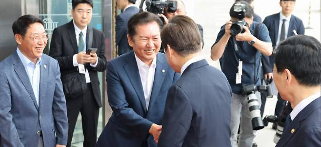 이재명 대통령이 26일 오전 서울 여의도 국회에서 추가경정예산안 시정연설을 위해 본청으로 향하던 중 더불어민주당 정청래 의원과 인사를 나누고 있다. 국회사진기자단