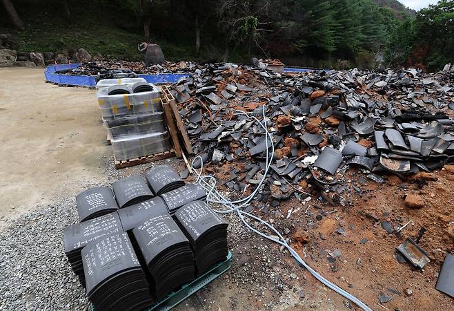 29일 오후 불에 탄 고운사 연수전 잔해 앞에 빠른 복구를 기원하는 기와불사용 기와가 쌓여 있다.