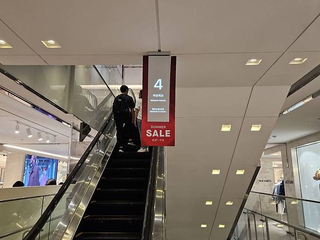 지난 27일 서울 중구 롯데백화점 본점 에스컬레이터 층 안내 팻말에 세일을 알리는 문구가 부착돼 있다. 사진=이정화 기자