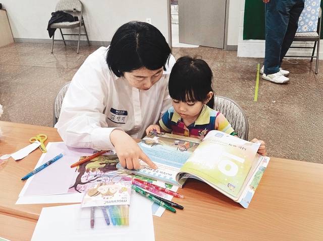 지난 22일 경기도 포천의 포천하랑센터에서 온누리교회 큐티사역팀 한 팀원이 이주민 2세 어린이에게 큐티책을 읽어주고 있다. 교회 제공