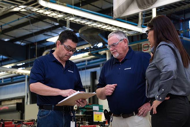 미국 앨라배마주에 위치한 화승코퍼레이션 미국법인의 자동차부품 생산현장에서 직원들이 현장회의를 하고 있다.