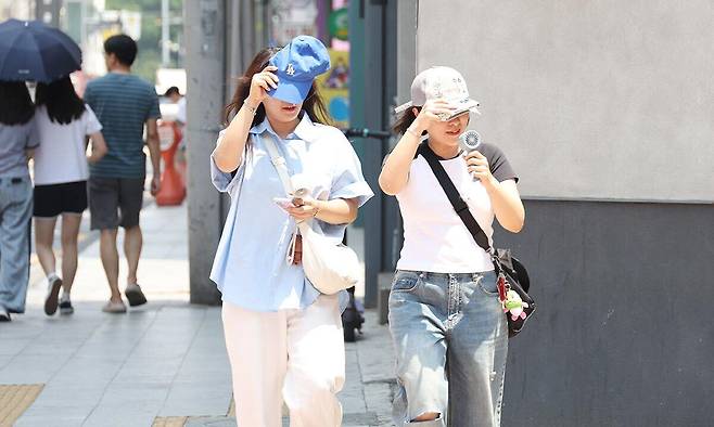 대구 중구 동성로에서 시민들이 햇볕을 가리며 발걸음을 옮기고 있다. 연합뉴스