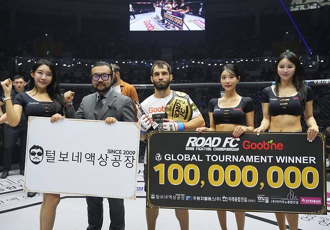 카밀 마고메도프(가운데)가 28일 서울 장충체육관에서 열린 ‘굽네 ROAD FC 073’ 라이트급 토너먼트 결승전에서 오카를 꺾고 우승을 차지한 뒤 황일영 털보네 액상공장 대표(왼쪽 2번째)와 함께 기념사진을 촬영하고 있다. 사진제공|로드FC