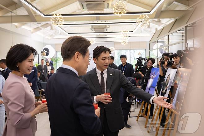 이재명 대통령과 부인 김혜경 여사가 30일 서울 용산 대통령실 파인그라스에서 열린 문화예술계 수상자 간담회에서 뮤지컬 '어쩌면 해피엔딩'으로 토니상 6관왕을 달성한 박천휴 작가에게 설명을 듣고 있다. (대통령실 제공. 재판매 및 DB 금지) 2025.6.30/뉴스1 ⓒ News1 이재명 기자