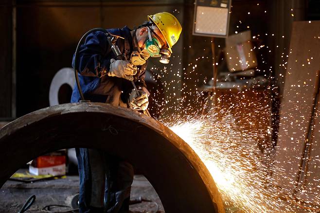 중국 동부 저장성 항저우의 한 기계 제조 회사에서 한 근로자가 철강 부품을 연마하고 있다. / AFP 연합뉴스