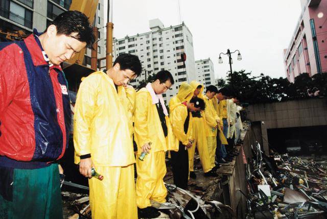 1995년 삼풍백화점 붕괴 사고 현장에서 자원봉사자들이 묵념을 하고 있다. 한국일보 자료사진