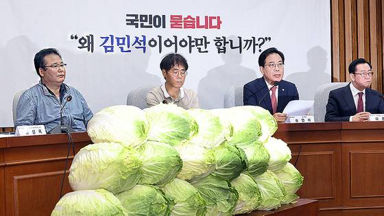 국민의힘 송언석 원내대표가 30일 국회에서 열린 김민석 국무총리 후보자 국민청문회에서 발언하고 있다. 회의장 연단 앞에는 배추 더미가 쌓여 있다. 연합뉴스