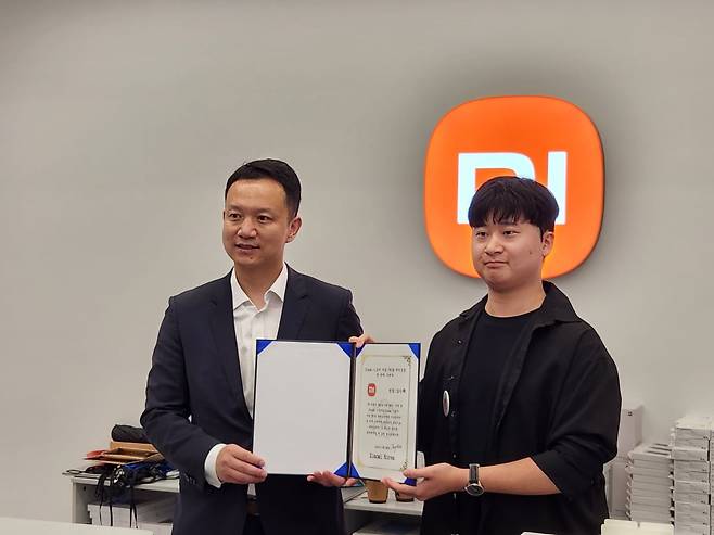 앤드류 리 샤오미 국제사업부 동아시아 지역 총괄(왼쪽)과 샤오미코리아 국내 첫 공식 매장 미스토어의 1호 구매자 장수혁 씨(23)가 기념촬영을 하고 있다. 사진=김대영 기자