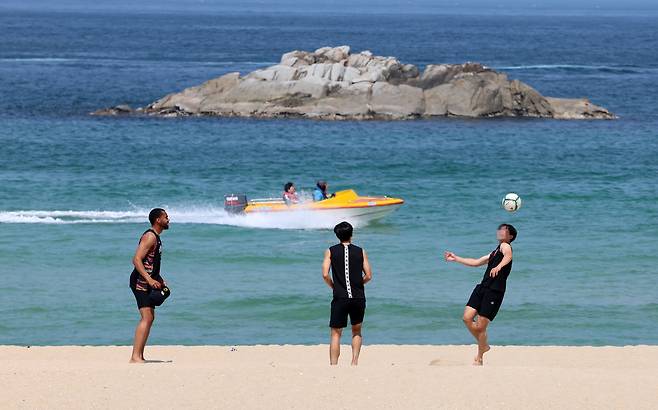 지난달 강원 강릉시 경포해변을 찾은 관광객들이 백사장에서 공놀이하고 있다. 연합뉴스