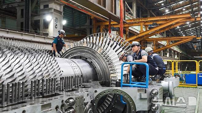 두산에너빌리티 관계자들이 발전용 대형 가스터빈을 조립하는 모습. /사진제공=두산에너빌리티