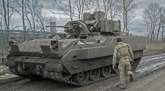 2023년 12월 4일 우크라이나 돈바스 전선에서 미국산 M2 브래들리 장갑차 옆에 서 있는 우크라이나 군인의 모습. 게티이미지/멀티비츠