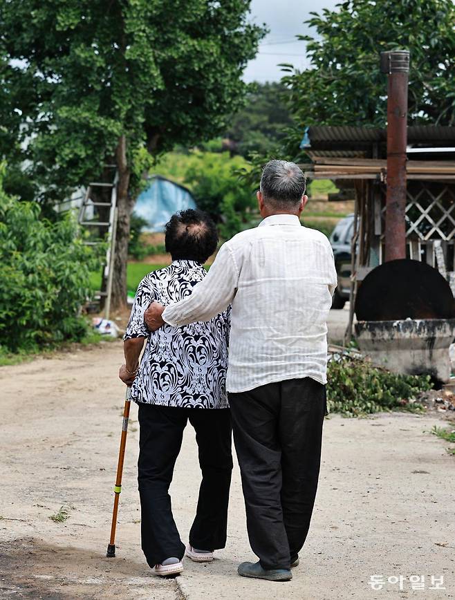 30일 오후 안무춘 씨(오른쪽)가 아내 김옥태 씨를 부축해 함께 동네를 산책하고 있다. 충남 서산시 해미면에 사는 안 씨 부부는 각각 2014년, 2015년 치매 진단을 받았다. 서산=양회성 기자 yohan@donga.com