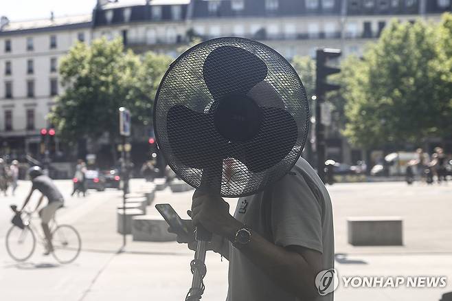 선풍기를 든 채 파리 시내를 걷는 남성 (파리 EPA=연합뉴스) 지난달 30일(현지시간) 한손에 선풍기를 든 남성이 프랑스 파리 시내를 걷는 모습. 2025.6.30