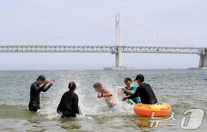 무더위가 기승을 부린 1일 개장한 부산 수영구 광안리해수욕장을 찾은 관광객들이 물놀이를 즐기며 더위를 식히고 있다. 2025.7.1/뉴스1 ⓒ News1 윤일지 기자